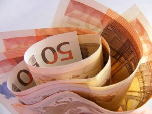 Várias notas de euro enroladas, bem-estar financeiro
